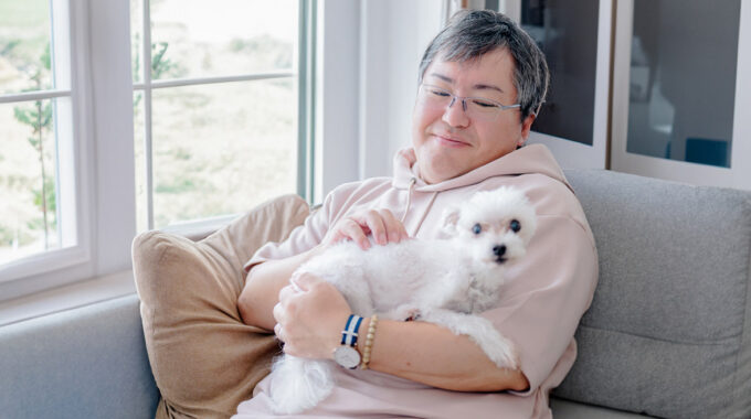 犬を抱っこして優しく撫でている