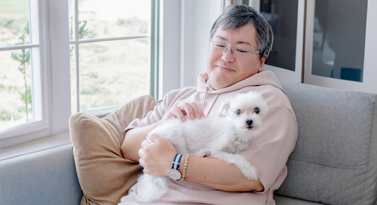 犬を抱っこして優しく撫でている